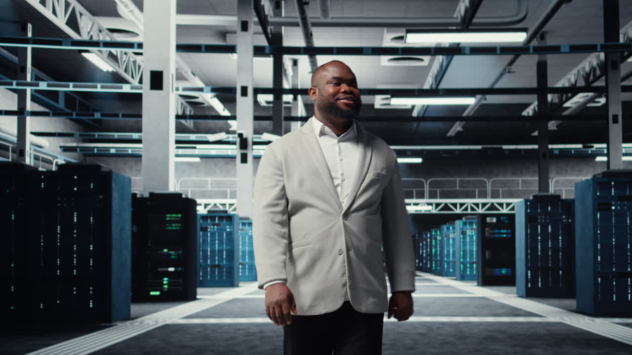 Vertical video Smiling engineer walking in data center, checking hardware for system stability