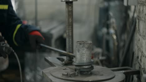el cerrajero dobla una barra de metal en una espiral en una máquina de doblar, trabajo de metal en el taller del herrero, 4k 60p prores hq