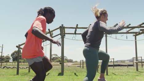Diverse-fit-group-running-through-tyres-on-obstacle-course-in-the-sun