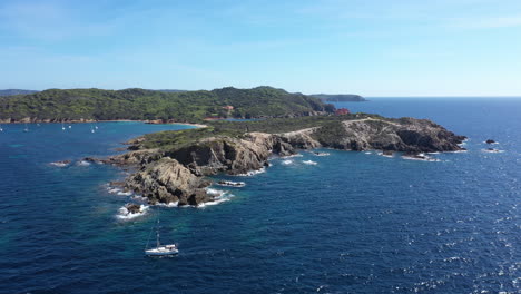 Sailing-boat-along-Porquerolles-coastline-sunny-day-Langoustier-beach