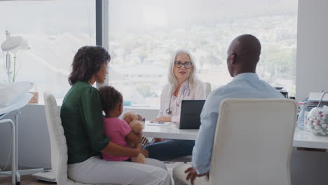 family with daughter in consultation with female doctor in office