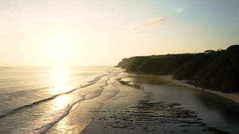 Goldenes-Sonnenlicht-Wird-Von-Warmem-Tropischem-Wasser-Reflektiert,-Wellen-Brechen-Am-Melasti-Beach,-Südbali,-Lufthyperlapse