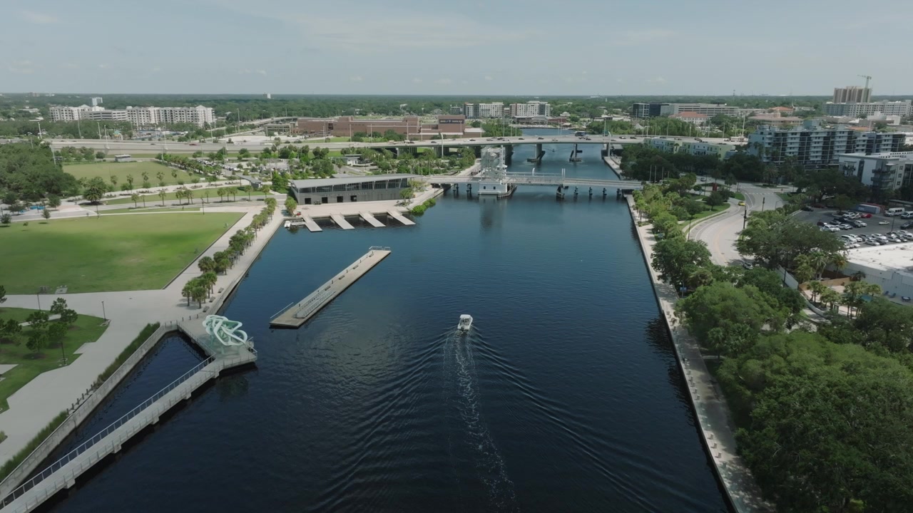 Drone Flight downtown tampa florida during the day following a boat in the riverwalk