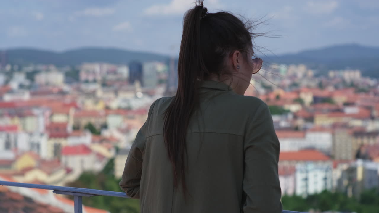 mujer mirando la vista de la ciudad desde un punto alto