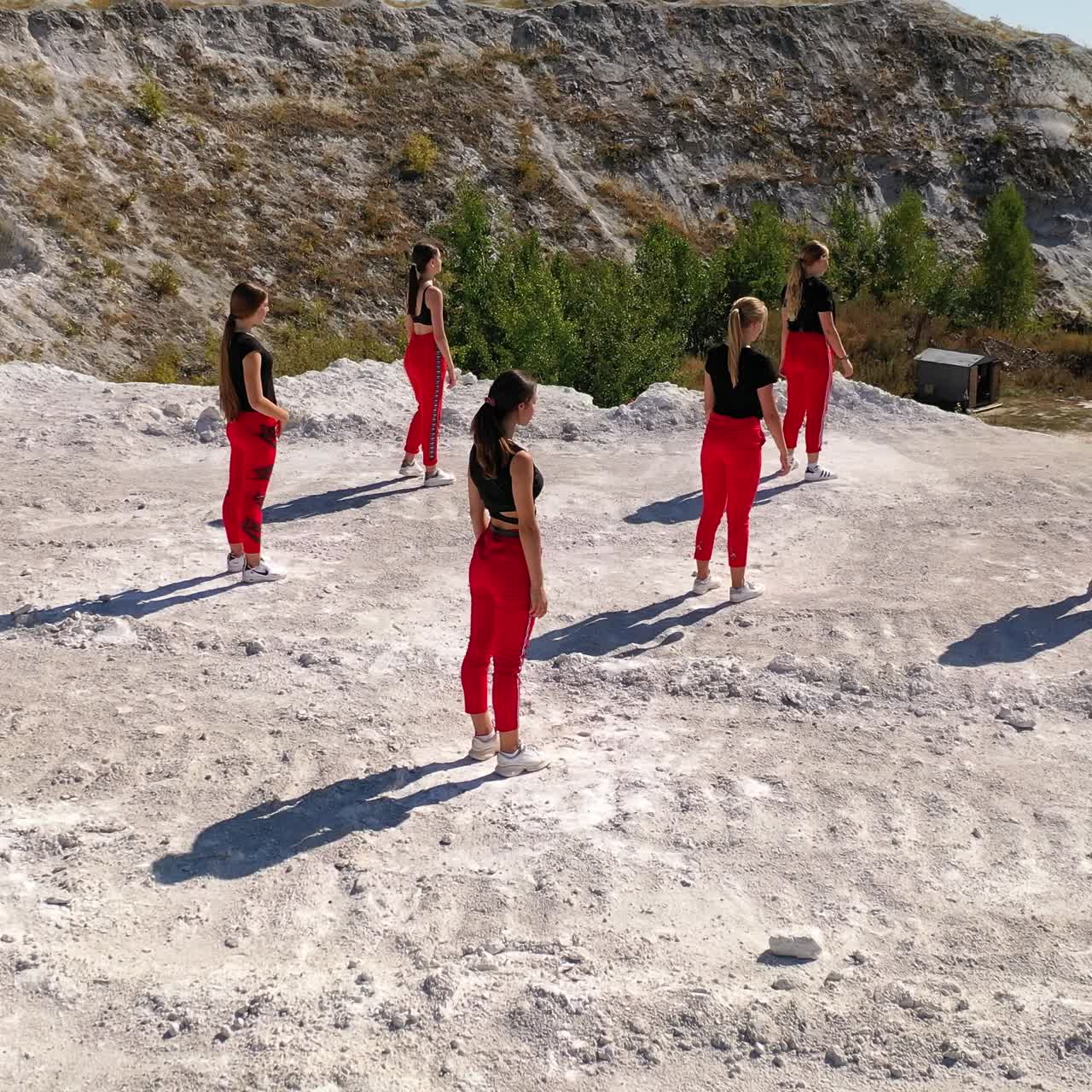 Girls' band dancing contemporary dances. Stylish dance performance on the white rocks on sunny day