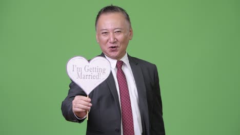 mature japanese businessman holding paper sign