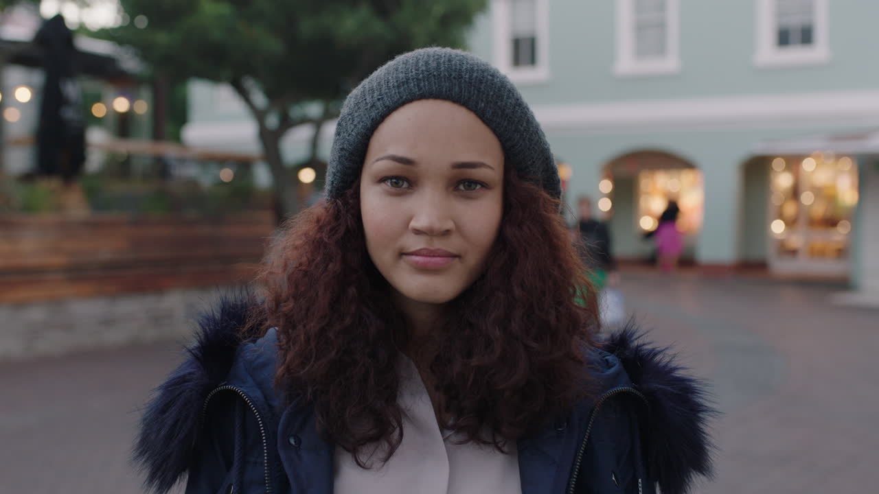 retrato de una hermosa mujer joven mirando a la cámara seria pensativa con abrigo de piel en el fondo urbano