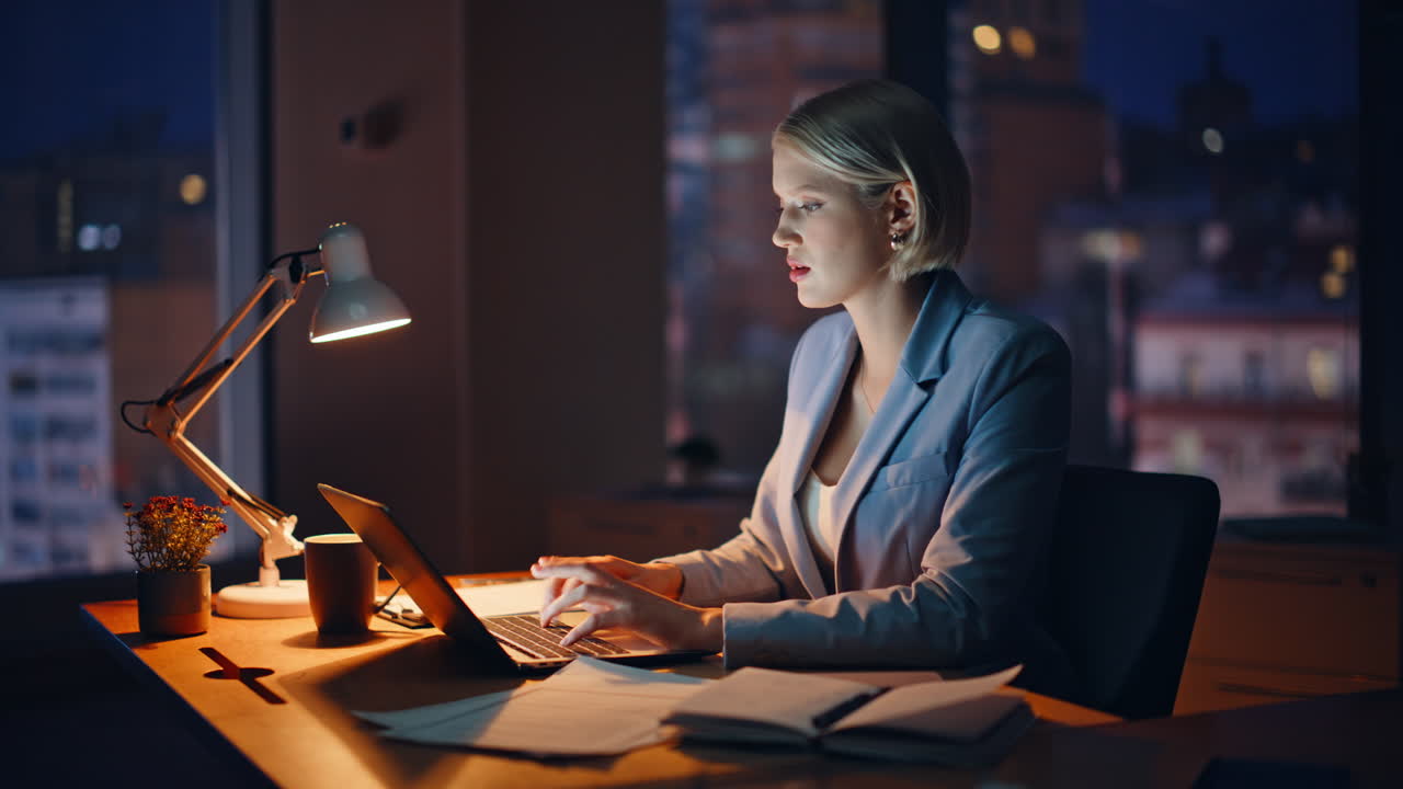 Manager planning project late evening in office. Businesswoman typing laptop