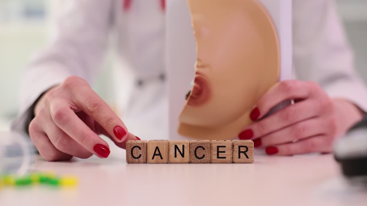 Doctor adds letter on wooden cube making word cancer