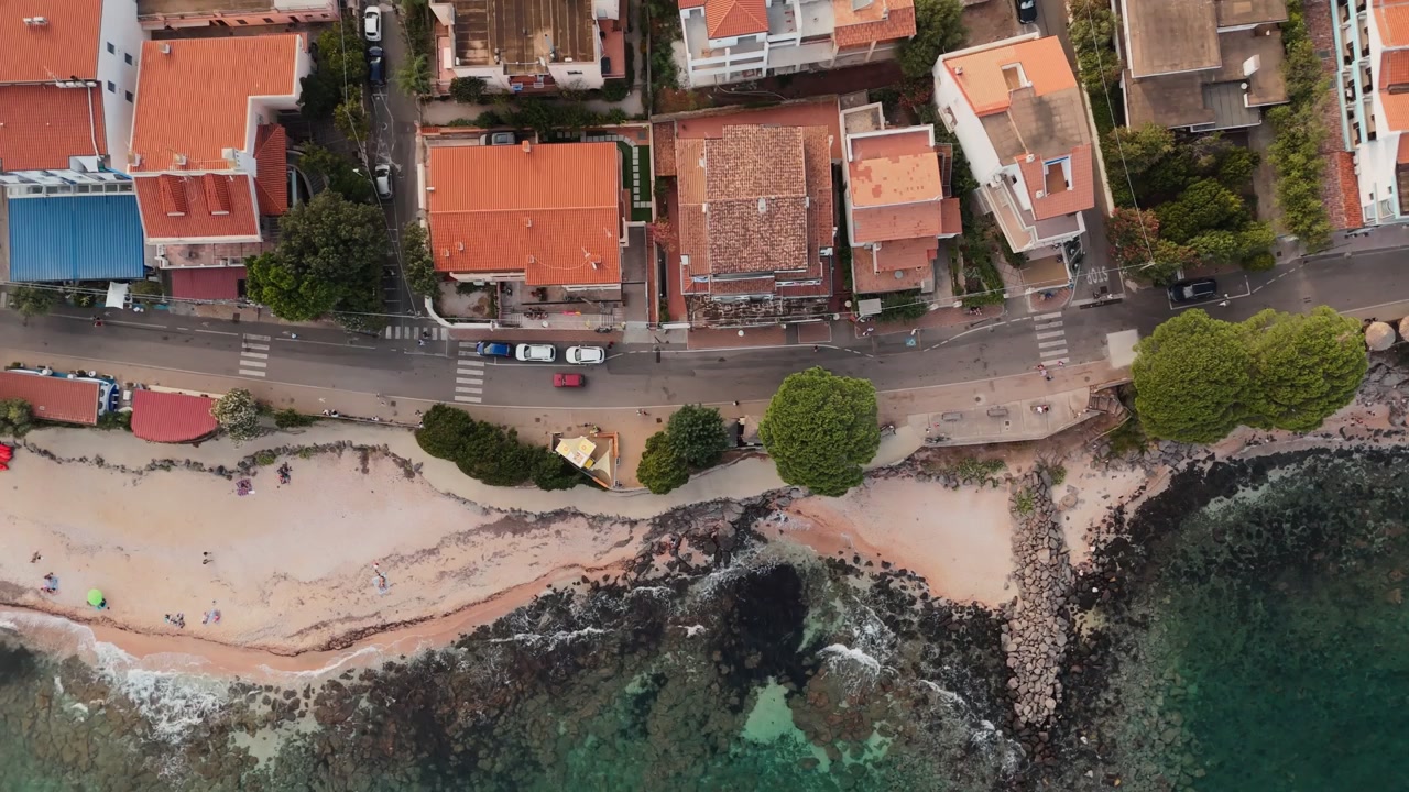 Cala Gonone, Sardegna, Italia, che mostra la costa mediterranea, gli edifici sul lungomare e la spiaggia sabbiosa lungo il Golfo di Orosei, vista aerea dall'alto