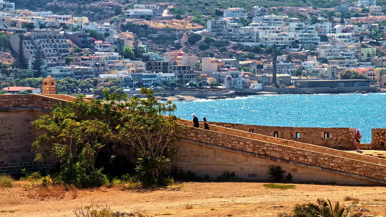 View of Venetian Fortezza Castle with sea and hillside cityscape in Crete on a sunny day