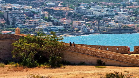 view of venetian fortezza castle with sea and hillside cityscape in crete on a sunny day