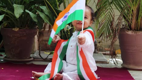 Lindo-Niño-Ondeando-La-Bandera-Tricolor-India-En-Tela-Tradicional-Con-Expresión-Facial-Inocente