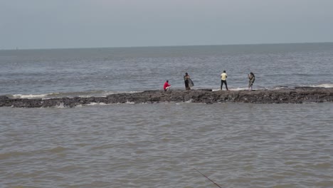 Nahaufnahme-Von-Wellen,-Die-Sich-Auf-Dem-Bandra-Fort-In-Mumbai,-Indien-Brechen,-Mit-Menschen-Beim-Angeln