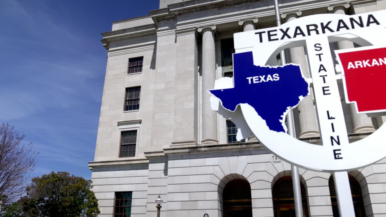 Texarkana delstatsgrænseskilt mellem Texas og Arkansas med gimbal-video, der panorerer fra venstre mod højre.