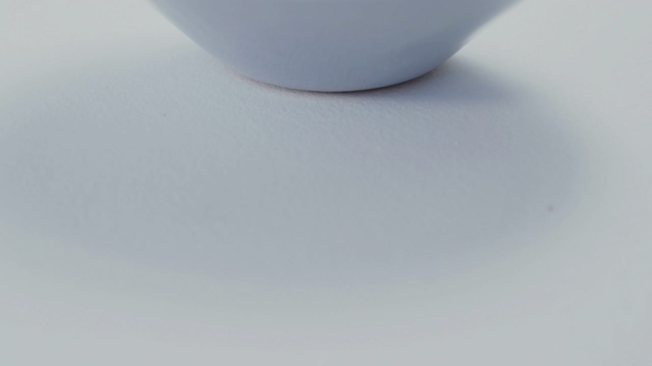 Droplets falling camera pulling back revealing salad bowl cup tilting pouring dressing showing hues