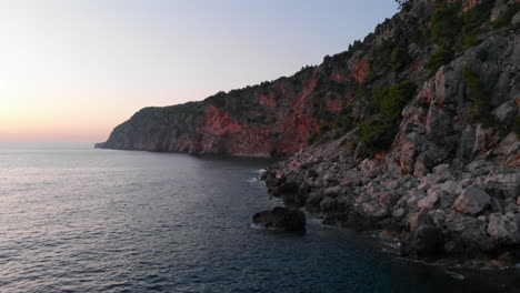 Acantilados-Costeros-Al-Atardecer,-Vuelo-Aéreo-Bajo-Sobre-El-Mar