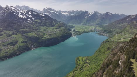 Vista-Aérea-Del-Pintoresco-Paisaje-Del-Lago-Walensee,-Suiza,-Con-Un-Sereno-Lago-Enclavado-En-Un-Valle-Rodeado-De-Montañas-Nevadas.