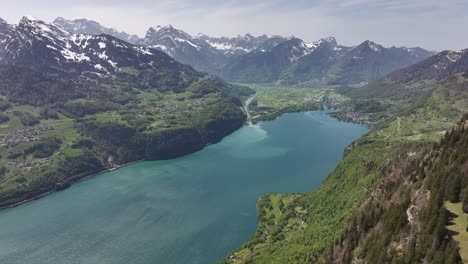 vista aérea del pintoresco paisaje del lago walensee, suiza, con un lago sereno enclavado en un valle rodeado de montañas cubiertas de nieve