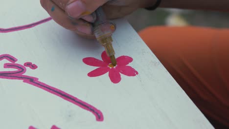 drawing flower finishing touches on sign