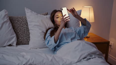 mujer usando el teléfono en la cama por la noche
