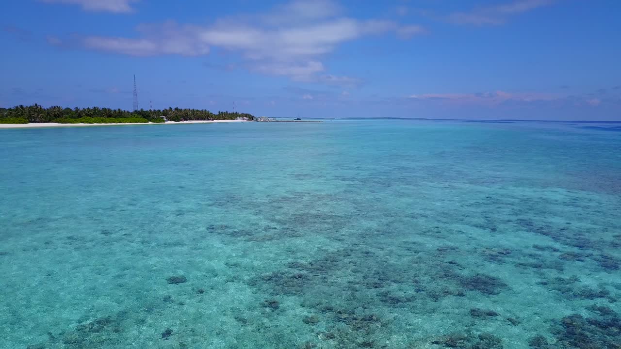 Incredibili acque cristalline e barriera corallina alle Maldive con l'isola di Fulidhoo in lontananza 4k.