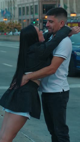 romantic commintment of woman and male embrace on busy street in downtown chicago at dusk