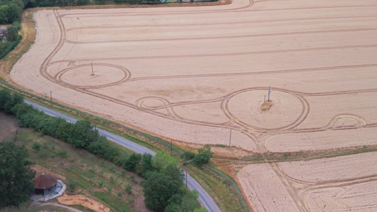 High angle drone shot showing harvested farm fields, utility poles, and rural landscapes in the UK countryside. Useful for sustainability and agricultural themes.