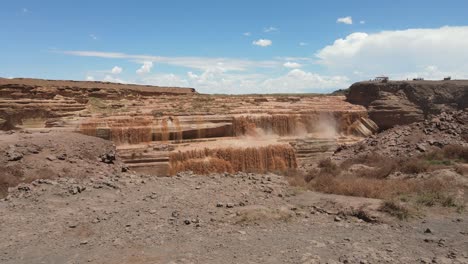 4K-drone-flying-over-the-edge-of-a-cliff-revealing-a-waterfall-in-Arizona-known-as-chocolate-falls,-grand-falls