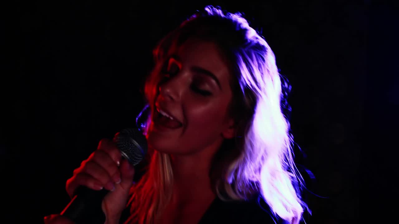 Female singer singing into a microphone 4k