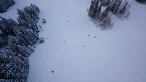 esquiadores y practicantes de snowboard corren por la ladera de una montaña cubierta de nieve en utah