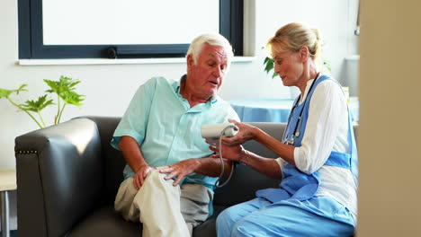 a nurse measuring blood pressure of a senior man
