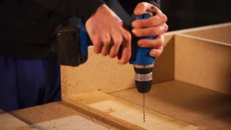 carpenter using a drill on wood