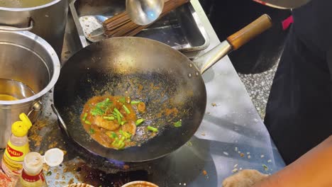 chef stir-frying food in a wok