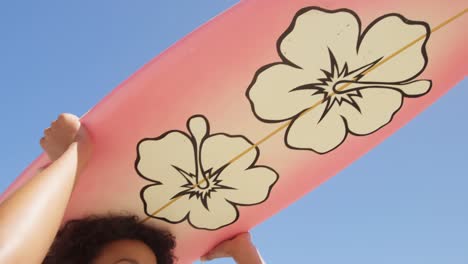 woman carrying surfboard on her head at beach 4k