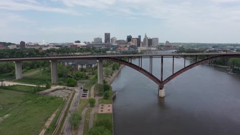 aerial dolly push-in shot of cars driving on high bridge over the mississippi river with downtown saint paul, minnesota in the distance