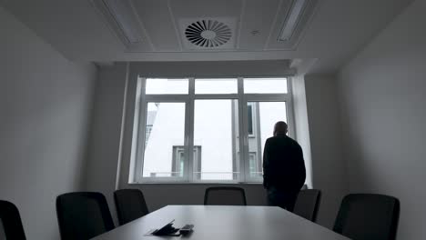 hombre cerca de la ventana, caminando de un lado a otro en la oficina - toma estática