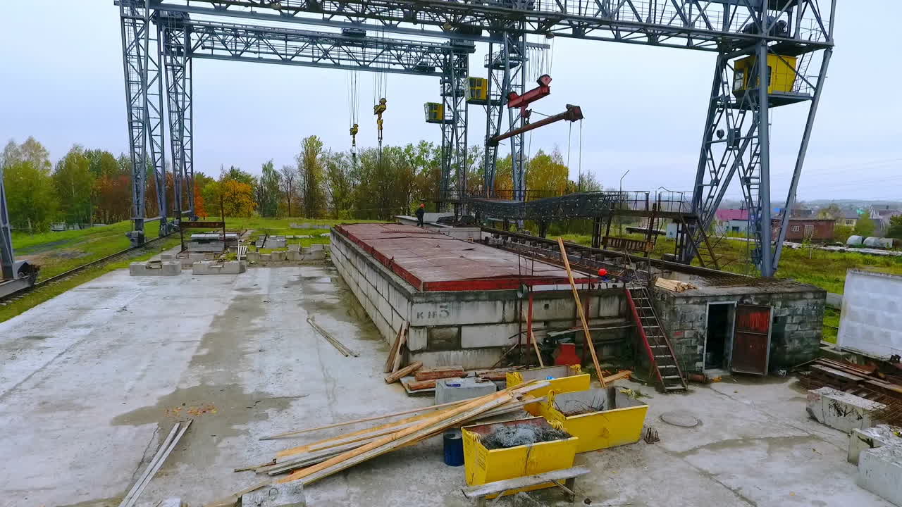 Aerial view industrial crane lowers loading. Crane working in factory dron view