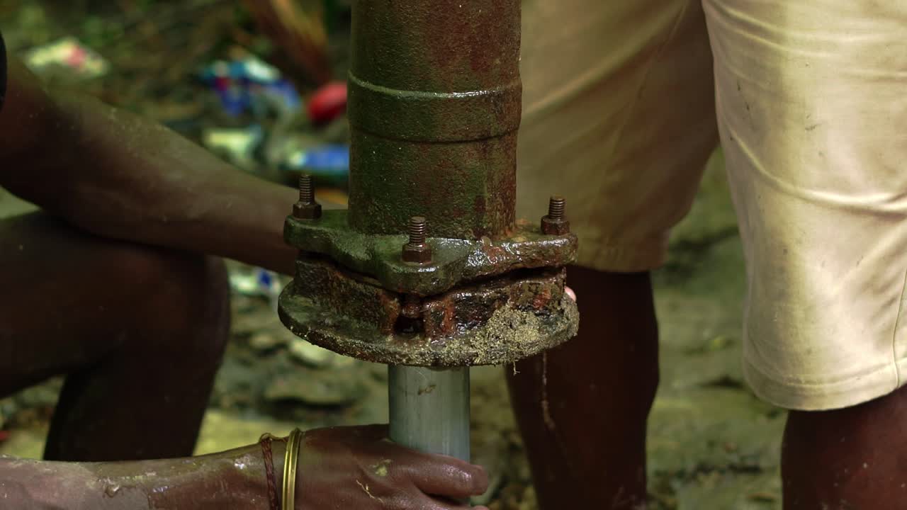 fontaneros instalando una bomba de agua trabajando en equipo en una aldea remota de áfrica