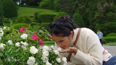 Atractiva-Latina-Disfruta-Del-Aroma-De-Las-Flores-Rosas,-Vista-De-Retrato