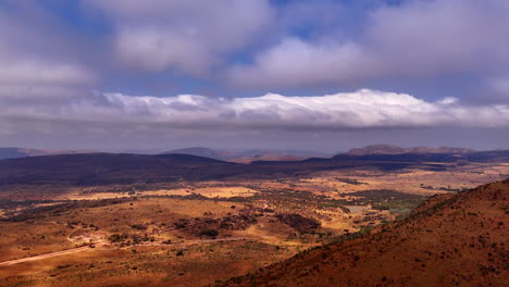 aerial drone: capturing a cold frontal cloud system moving over into a sunny mountainous valley