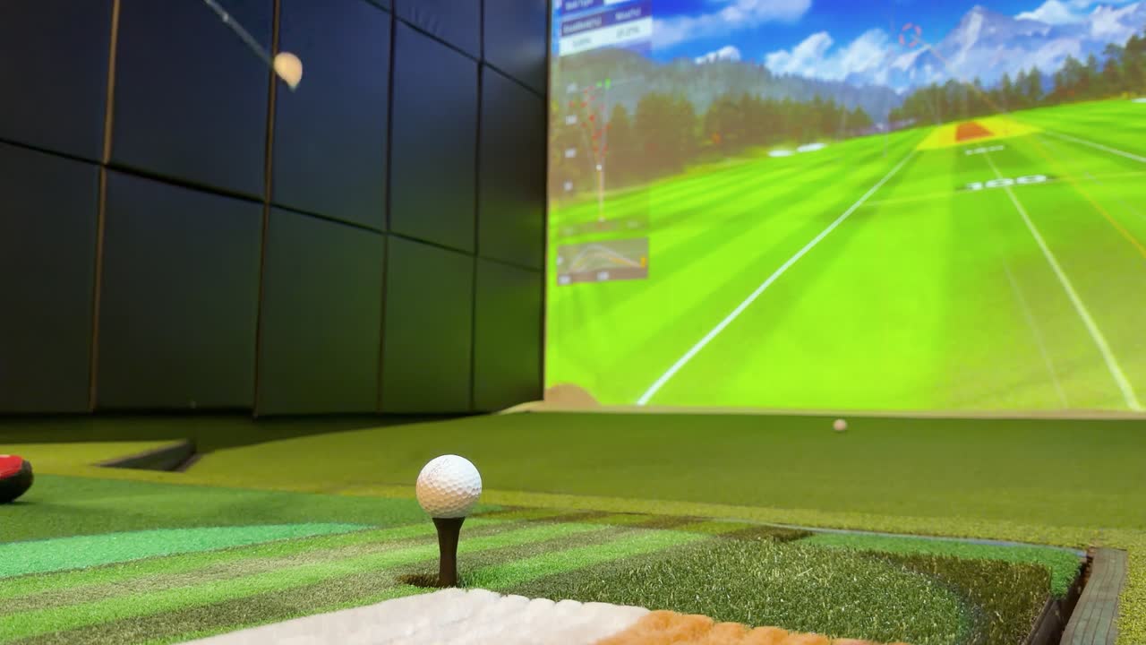 Low-angle view of indoor golf simulator as golfer hits ball, tracking ...