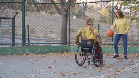 young man in wheelchair playing basketball in slow motion.