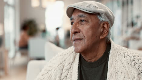 a senior man with a kind smile and a thoughtful expression sitting indoors