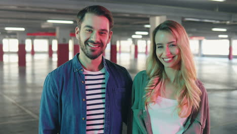 portrait shot of young caucasian good looking couple looking at each other and then smile at the camera