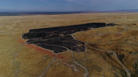 4k-drone-pan-pull-back-with-climb-of-fresh-burn-scars-from-a-grass-fire