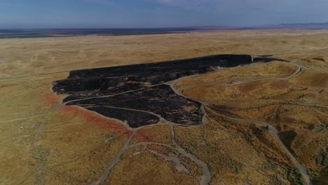 4k drone pan retroceder con la escalada de cicatrices de quemaduras frescas de un incendio de hierba