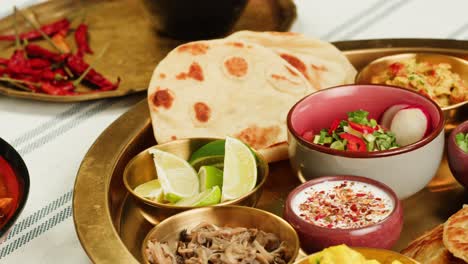 assorted indian sri-lanka food set on wooden background. dishes and appetisers of indeed cuisine, rice, lentils, paneer, samosa, spices, masala. bowls and plates with indian food top view chicken. high quality 4k footage
