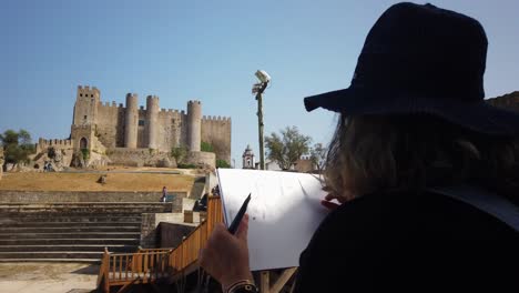 woman sketching a medieval castle