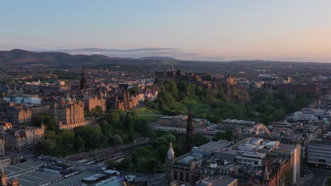 drone shot of edinburgh, scotland uk, cityscape and historic buildings on golden hour sunlight